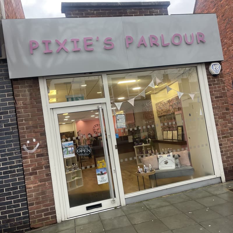The shopfront with bunting and a lit window display, cropped below the lettered fascia